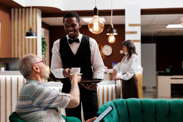 Un serveur d'hôtel sert du café à des personnes âgées.