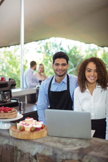 Serveur masculin et serveuse avec ordinateur portable