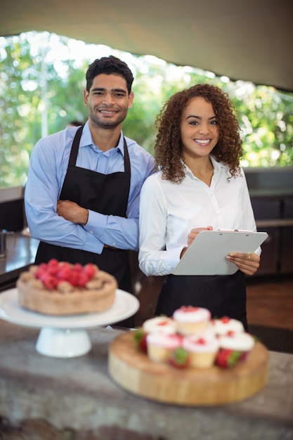 Serveur masculin et serveuse avec presse-papiers