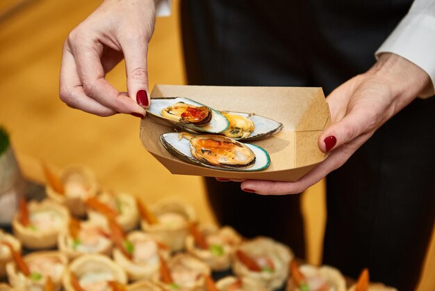 Photo le serveur met de la nourriture dans la boîte pendant l'événement