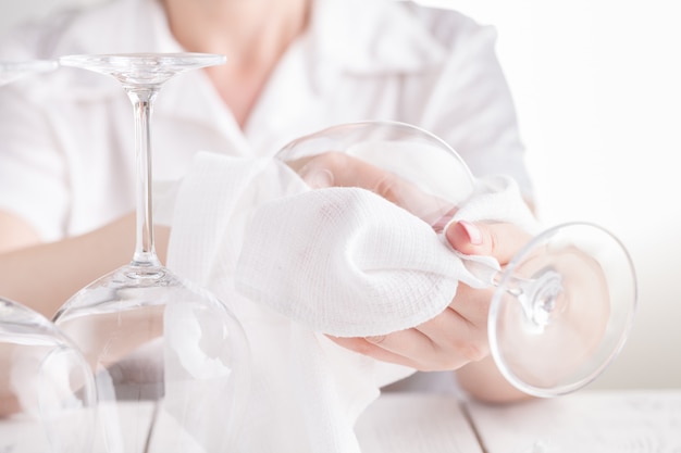 Le serveur polit le verre. Une femme barman polit un verre de verres à vin