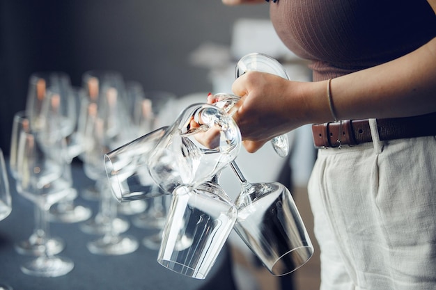 Un serveur prend quelques verres à vin vides de la table du bar en gros plan sans visage Service de restaurant