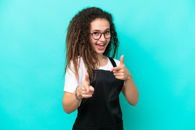 Serveur de restaurant femme arabe isolée sur fond bleu pointant vers l'avant et souriant