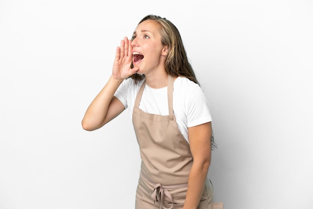 Serveur de restaurant femme caucasienne isolée sur fond blanc criant avec la bouche grande ouverte sur le côté