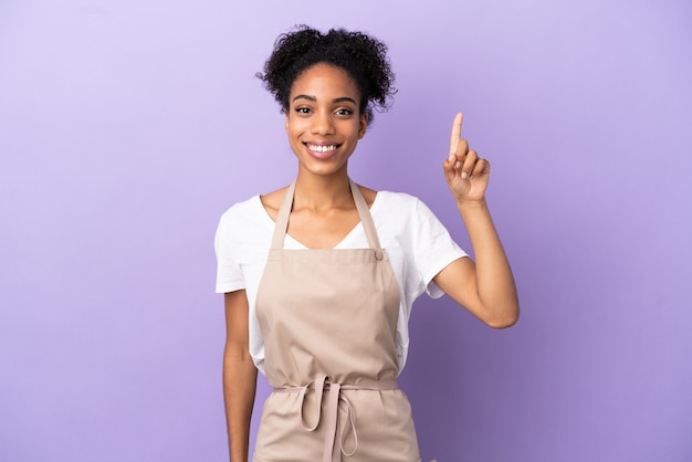 Serveur de restaurant femme latine isolée sur fond violet pointant vers une excellente idée