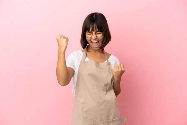 Serveur de restaurant sur fond rose isolé célébrant une victoire