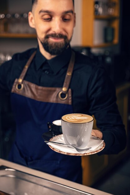 Le serveur sert du café chaud.