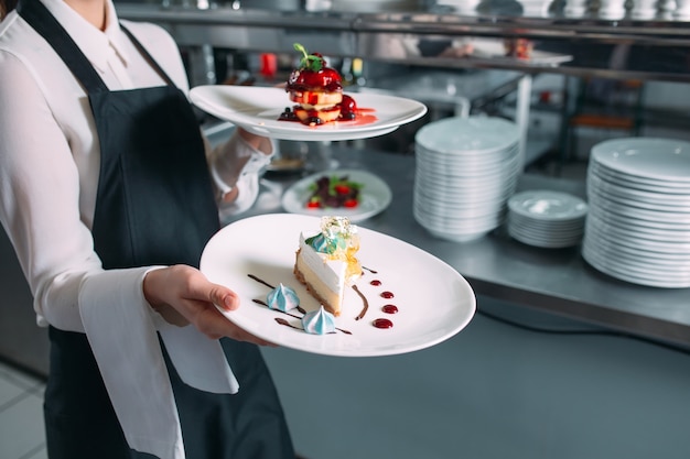 Serveur servant en mouvement en service au restaurant. Le serveur porte des plats