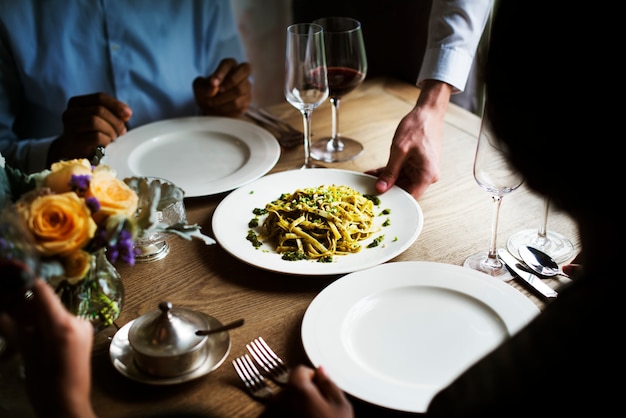 Serveur servant des plats de pâtes aux clients