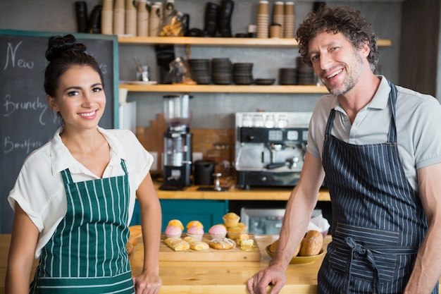 Serveur et serveuse debout au comptoir de la cafétéria