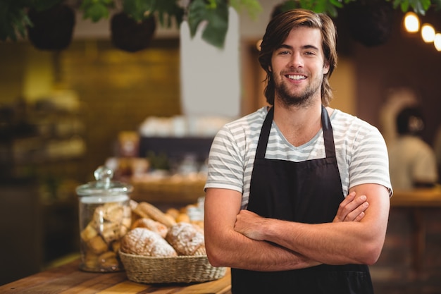 serveur souriant, debout, bras croisé