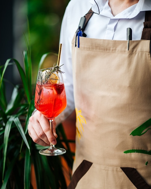 Serveur tenant un verre de cocktail aperol spritz