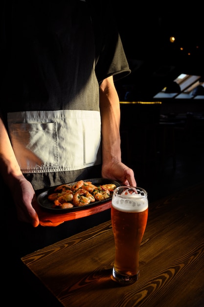 Photo le serveur tient un plat de crevettes