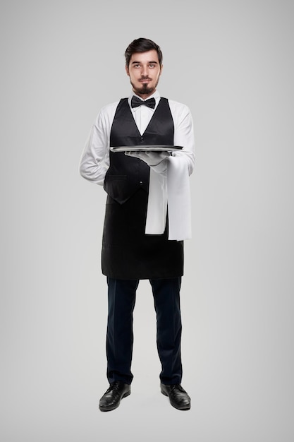 Serveur en uniforme noir et blanc avec plateau