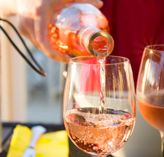 Photo le serveur verse le vin rose français dans le verre sparks