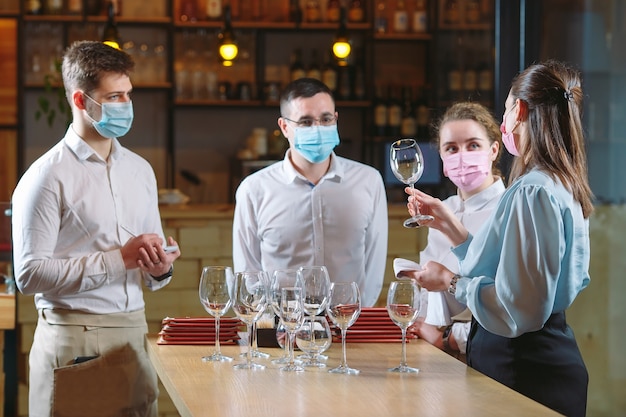 Les serveurs du restaurant dans un masque médical apprennent à distinguer les verres.