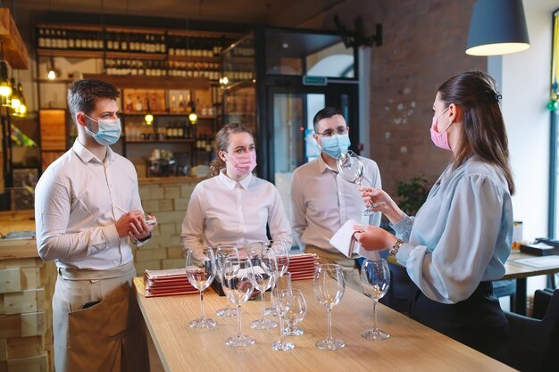 Les serveurs du restaurant dans un masque médical apprennent à distinguer les verres.