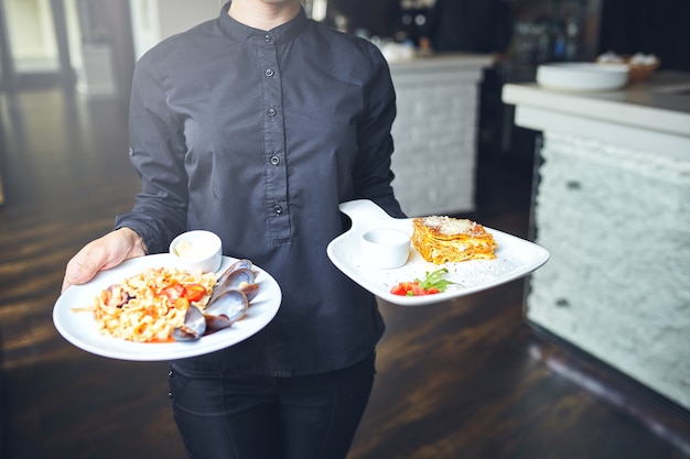 Serveurs portant des assiettes avec plat de viande lors d'un mariage.