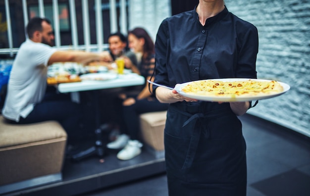 Serveurs portant des assiettes avec plat de viande lors d'un mariage.