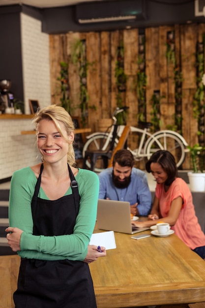 Serveuse, debout, bras croisés