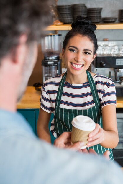 Photo serveuse donnant une tasse de café au client