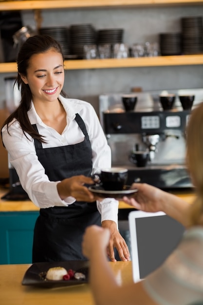 Serveuse offrant une tasse de café