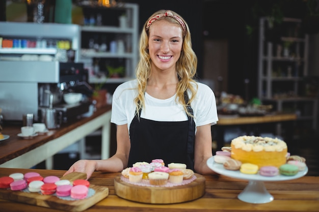 serveuse souriante debout avec dessert