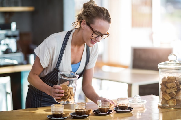 Photo serveuse travaillant au comptoir au café