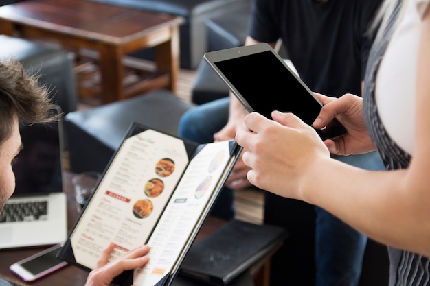 Serveuse utilisant une tablette numérique lors de la prise de commande au restaurant