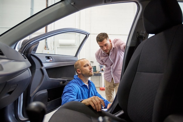 service automobile, réparation, entretien et concept de personnes - mécanicien et homme ou propriétaire au magasin de voitures