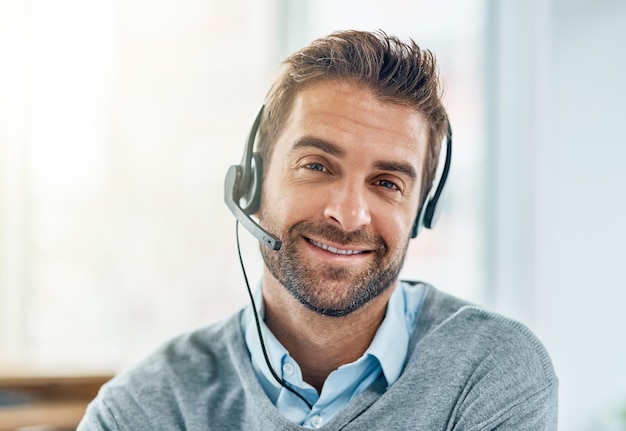 Le service client est très important pour nous Portrait d'un jeune agent de centre d'appels travaillant dans un bureau