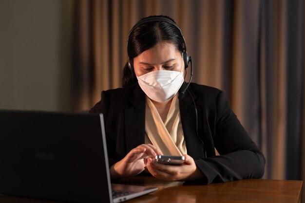 Service client de télémarketing femme asiatique portant un masque facial travaillant dans le bureau du centre d'appels
