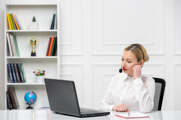 Service à la clientèle jolie fille blonde chemise de bureau avec casque et ordinateur pensant