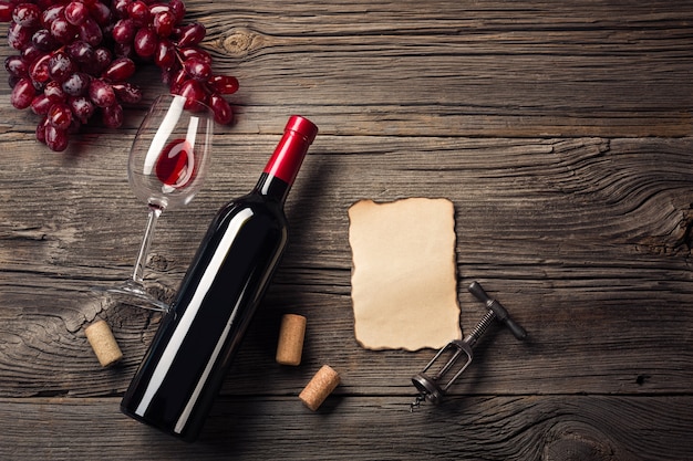 Service de dîner de fête avec vin rouge et cadeau sur bois rustique. Vue de dessus avec un espace pour vos salutations.