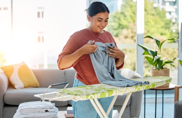 Service de nettoyage de blanchisserie et de planche à repasser pour femme et travailleur domestique avec un sourire heureux et travaillant à la maison