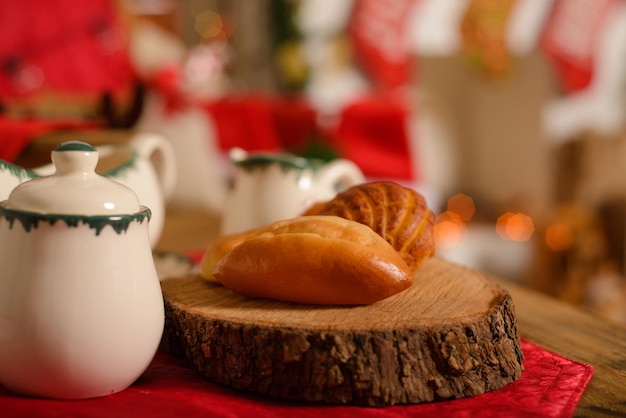 Service à thé avec décorations de Noël et pains en premier plan avec fond de Noël