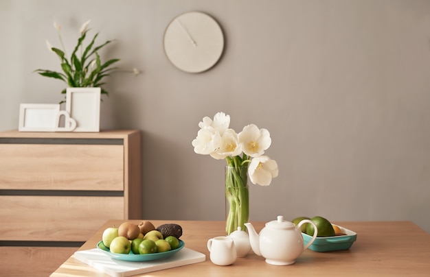 Service à thé sur table en bois. Décoration d'intérieur, bouquet de fleurs dans un vase, table avec ensemble de théière. Bonjour concept. Petit déjeuner anglais. Petit déjeuner en chambre d'hôtel