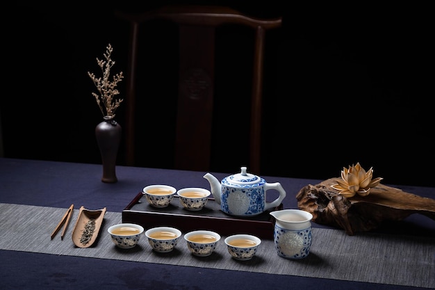 Un service à thé avec des tasses à thé et un vase de thé sur une table.