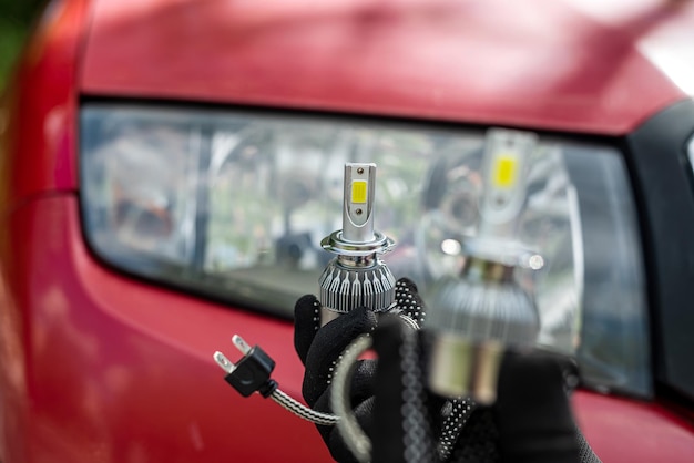 Service de voiture où les hommes tiennent une lampe halogène pour réparer ou changer un phare