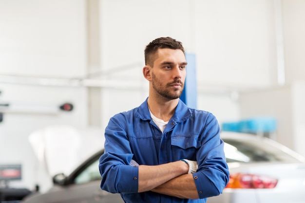 service de voiture, réparation, entretien et concept de personnes - mécanicien automobile ou forgeron à l'atelier