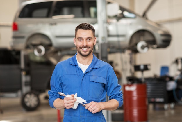 Photo service de voiture, réparation, entretien et concept de personnes - mécanicien automobile ou forgeron avec clé à l'atelier