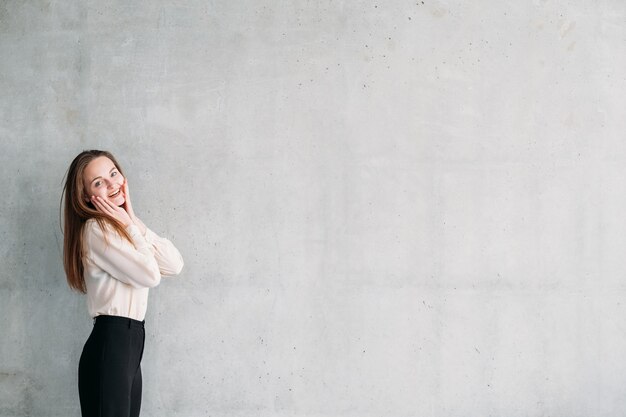 Services de marketing d'entreprise. Jeune femme excitée avec les mains touchant les joues.