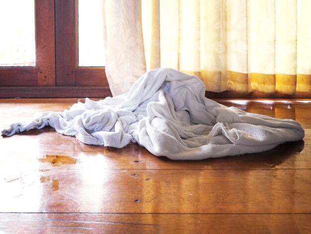 Serviette blanche sur un sol en bois marron dans la chambre.