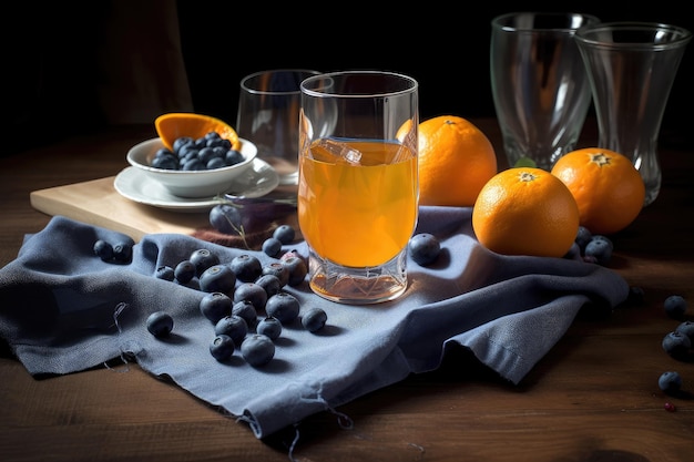 Une serviette blanche sur une table en bois avec des myrtilles et du jus d'orange dans des tasses en verre