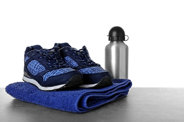 Serviette et bouteille de chaussures de sport sur la table