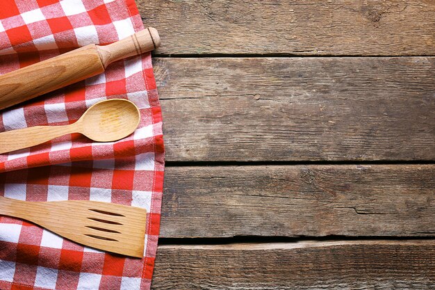 Serviette à carreaux et couverts sur fond de bois