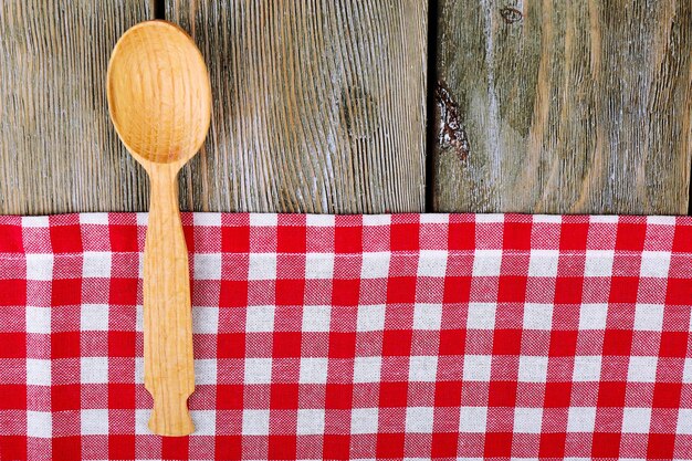 Serviette à carreaux avec cuillère sur fond de table en bois