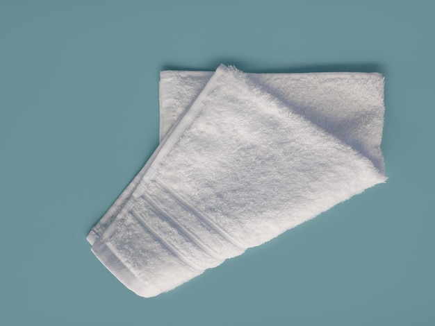 Photo serviette en coton blanc pliée isolée sur fond bleu