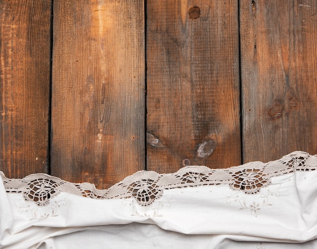 Serviette de cuisine blanche sur fond en bois marron, vue du dessus, espace copie