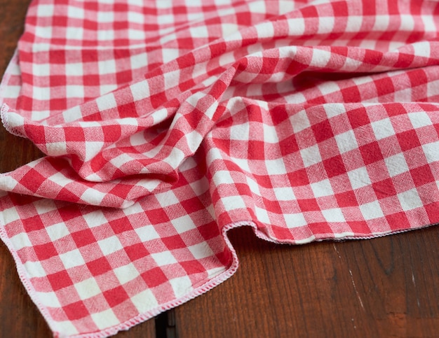 Serviette de cuisine textile rouge et blanc sur un fond en bois brun